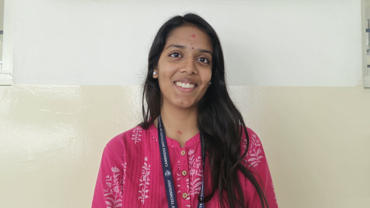 Kirthi JC smiling in a pink kurta